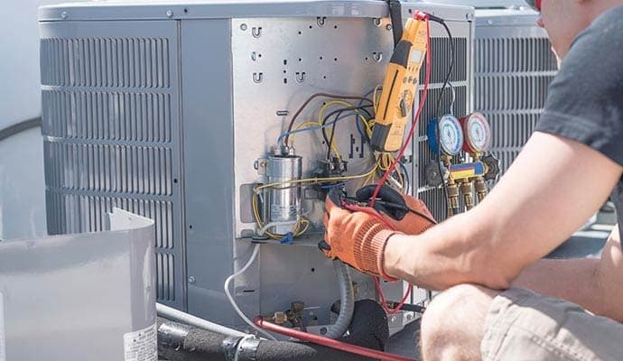 Ghetti & Sons HVAC technician servicing an air conditioner in Phoenix, AZ